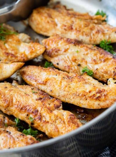 close up view of chicken tenders in a pan