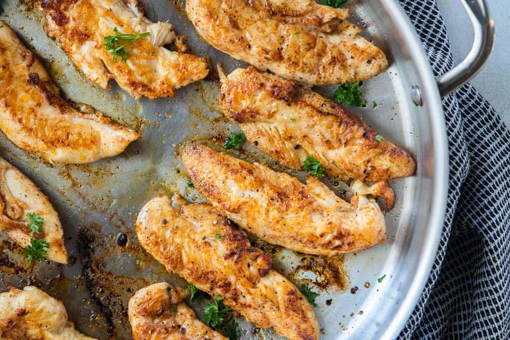 top down view of seasoned chicken tenders in a pan