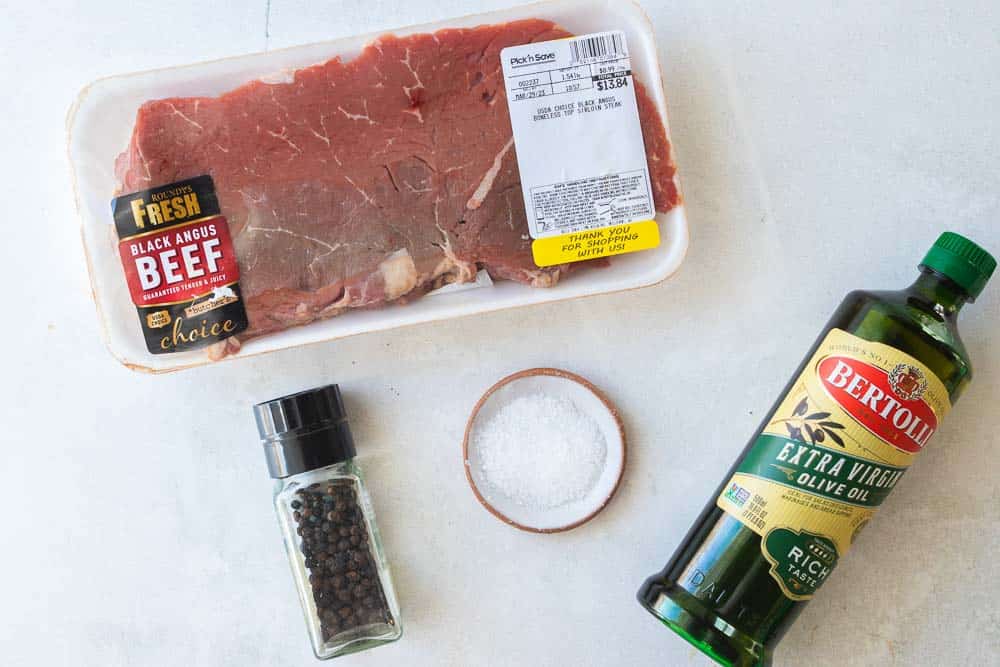 sirloin steak, olive oil, salt and pepper displayed