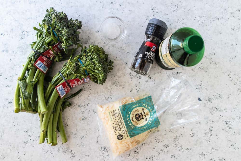 broccolini, salt, pepper, olive oil and parmesan cheese displayed