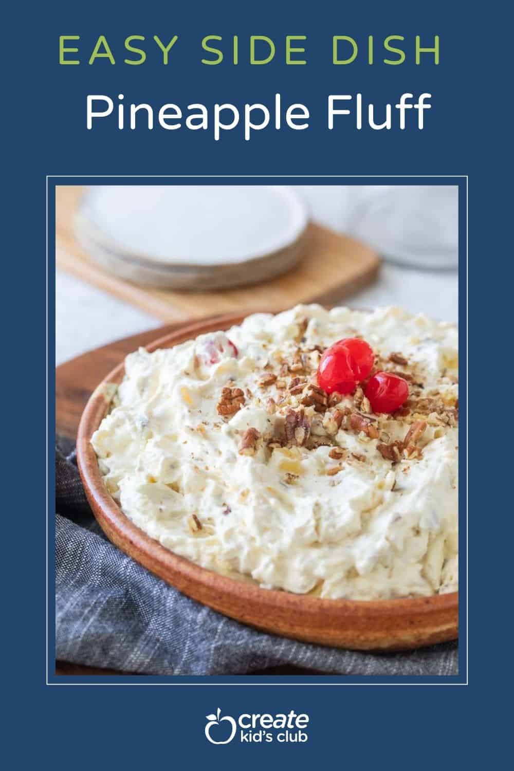 pineapple fluff in bowl topped with crushed pecans and maraschino cherries