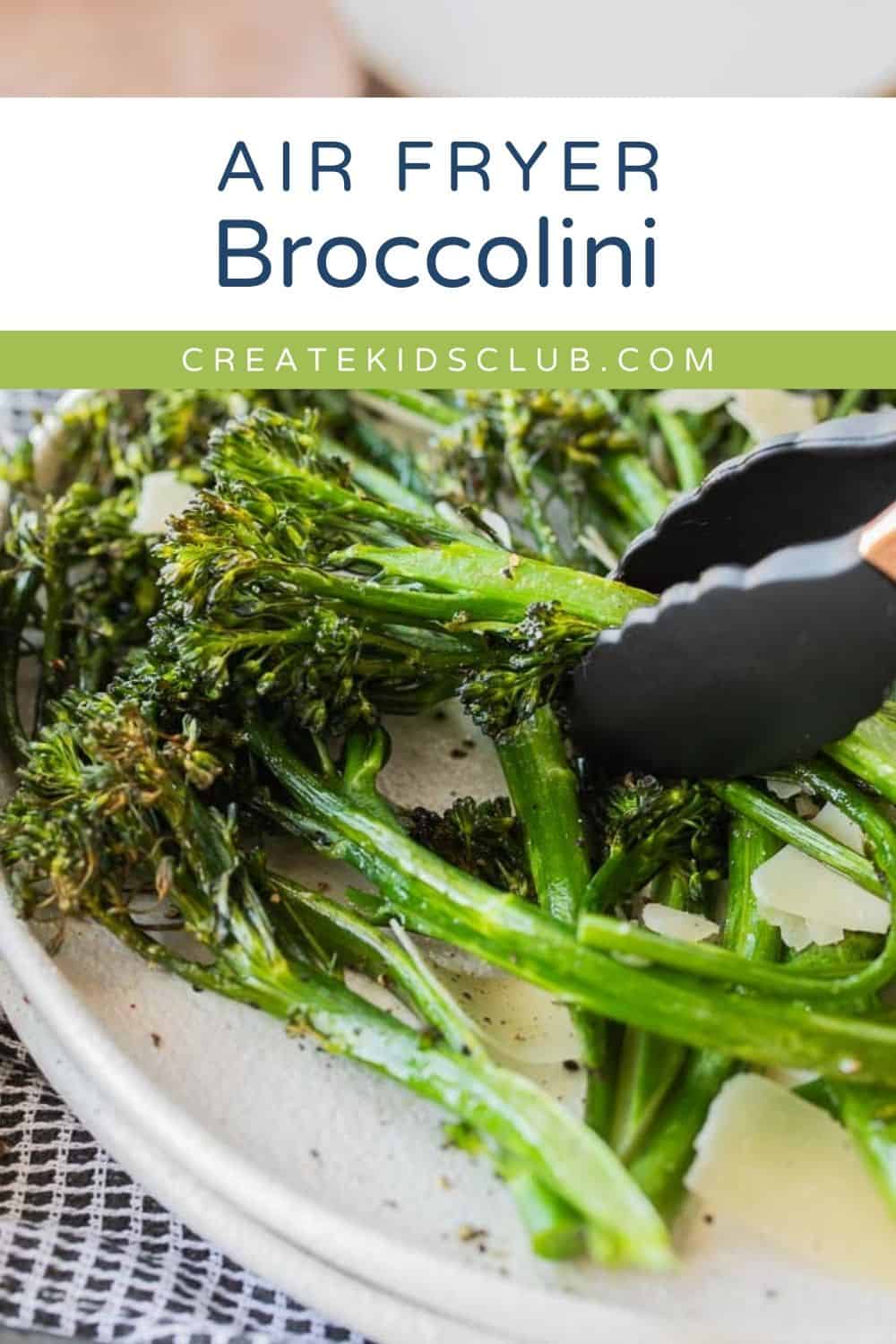 a pin of broccolini on a plate with a tong picking some up