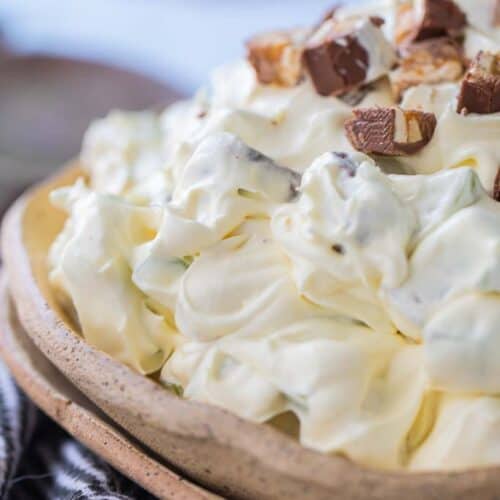 taffy apple salad in bowl topped with snickers bars