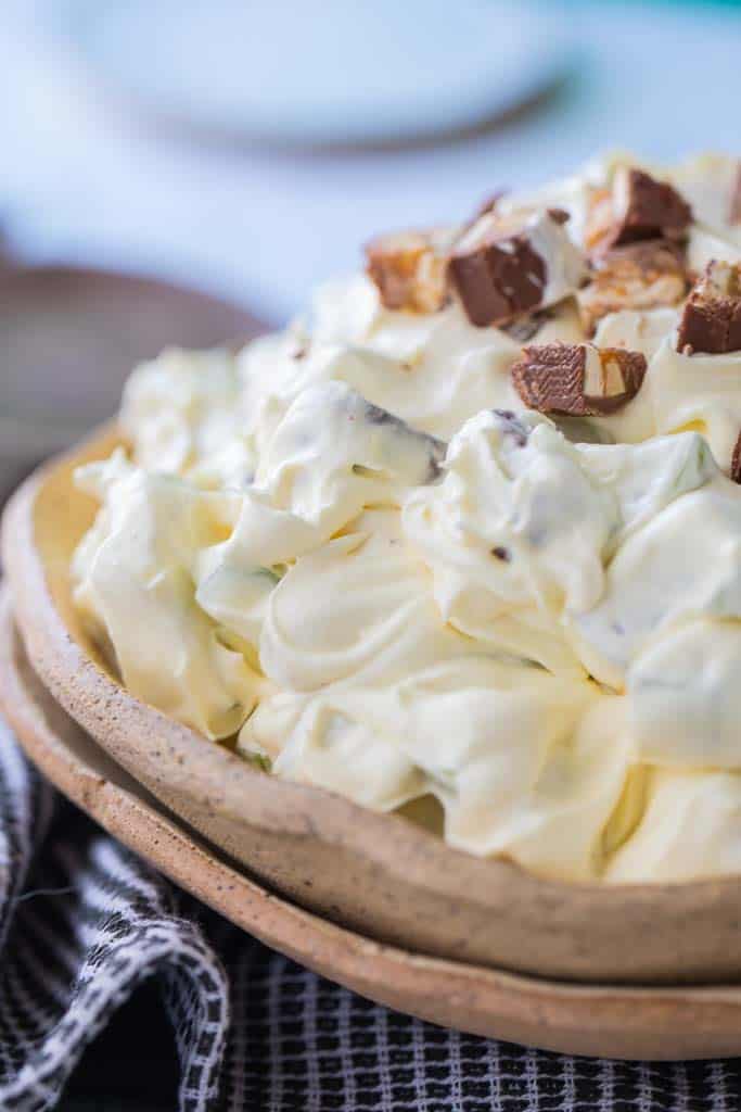 taffy apple salad in bowl topped with snickers bars