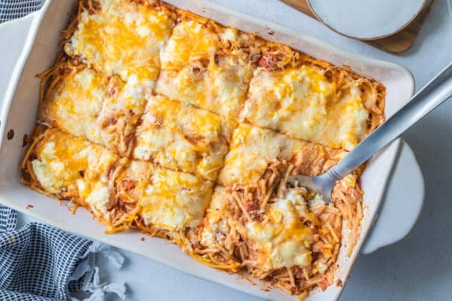 top down view of spatula in dish of baked spaghetti