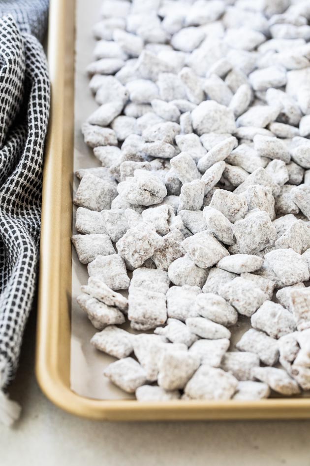 close up of Chex mix muddy buddies on a baking sheet