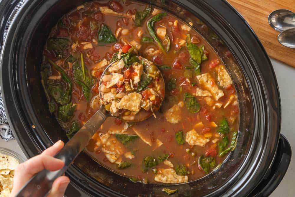 ladle scooping chicken tortilla soup from slow cooker