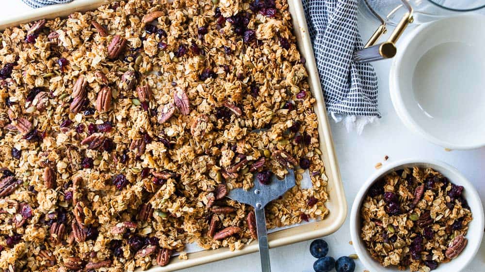 spatula scooping up gluten free granola from sheet pan