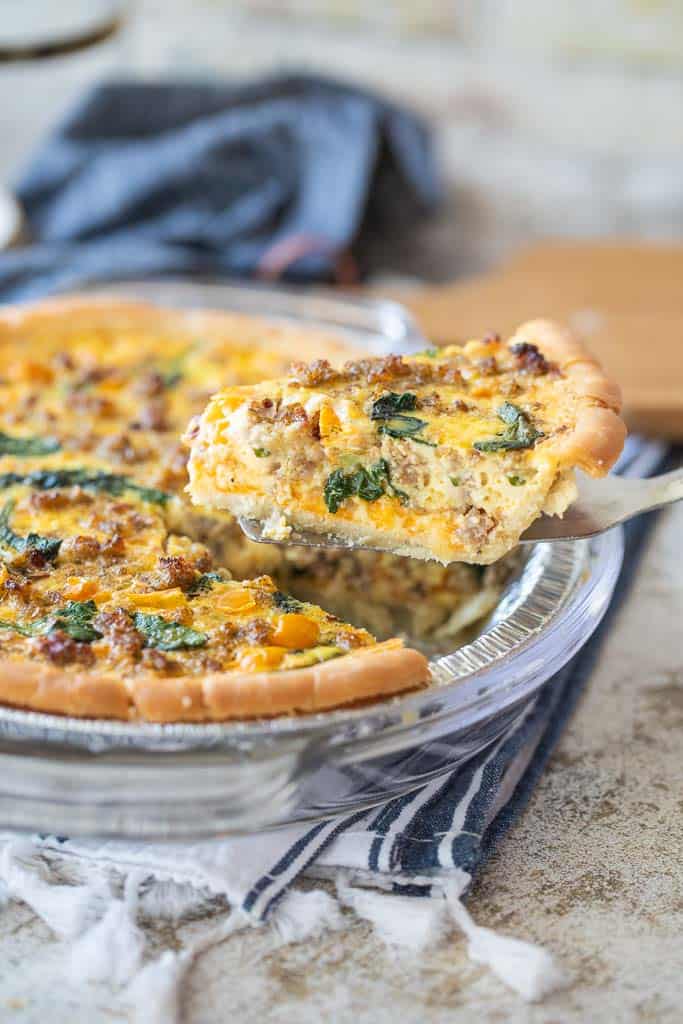 spatula removing slice of quiche from pie plate