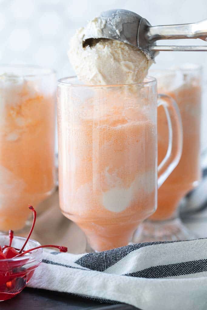 scoop of vanilla ice cream added to ice cream float