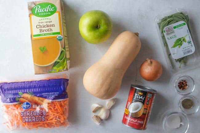 broth, green apple, butternut squash, spices, coconut milk, garlic, onion and shredded carrots displayed