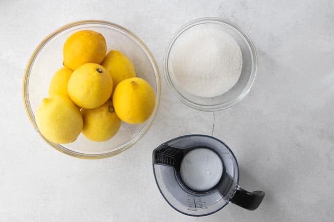 whole lemons, sugar and water displayed