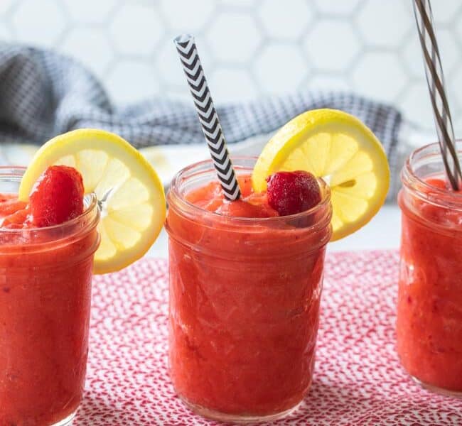 glass jars filled with frozen strawberry slushies