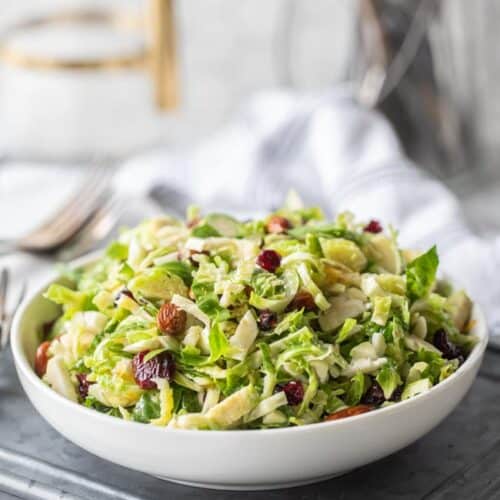 white serving bowl filled with shredded brussels sprout salad