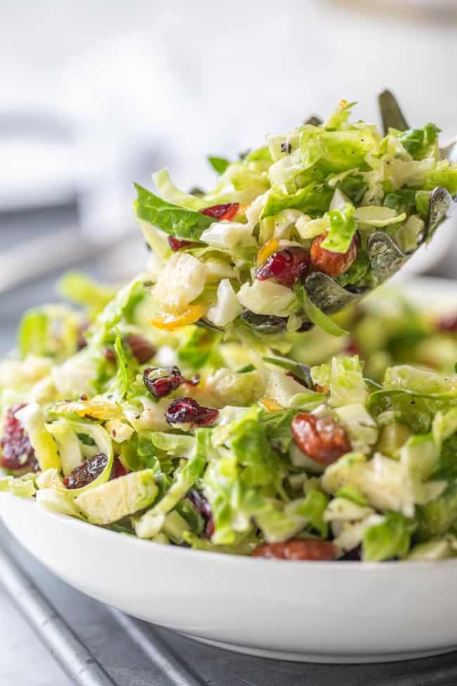 shredded brussels sprout salad scooped from a bowl