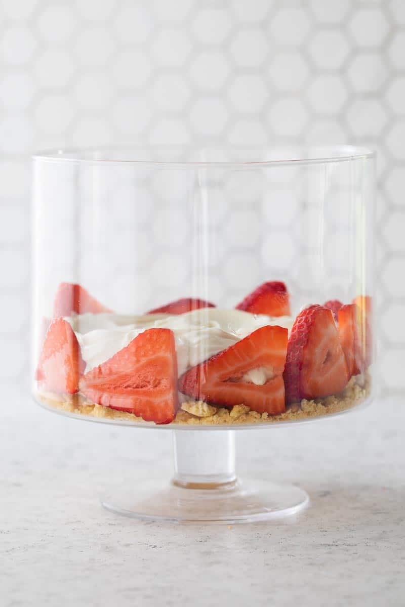 trifle bowl with crushed vanilla wafers on bottom then sliced strawberries and cool whip on top