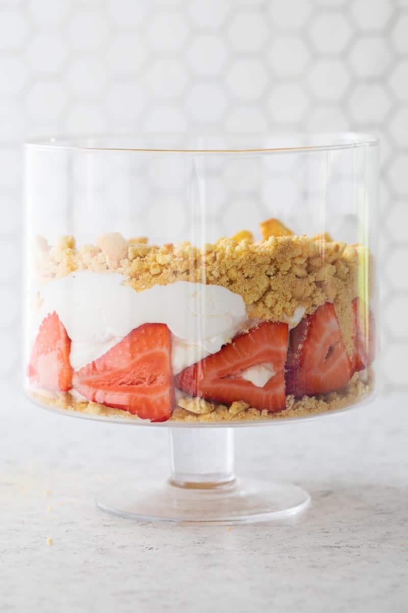 trifle bowl with layered with crushed vanilla wafers, sliced strawberries and cool whip