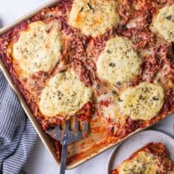 top down view of spatula scooping lasagna from sheet pan