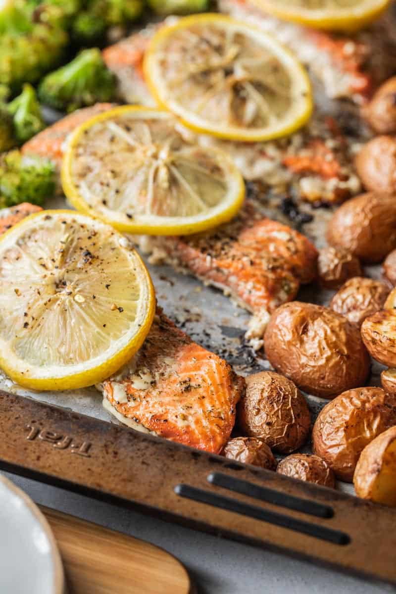 roasted red potatoes, salmon filets and broccoli on a sheet pan