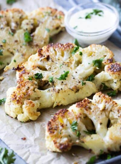 seasoned cauliflower steaks on parchment paper