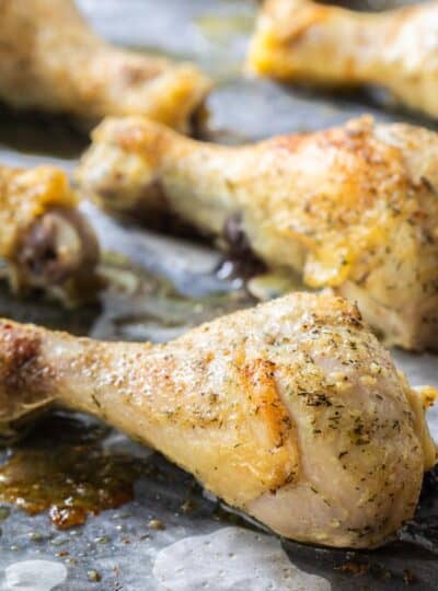 close up of baked chicken drumsticks on a sheet pan