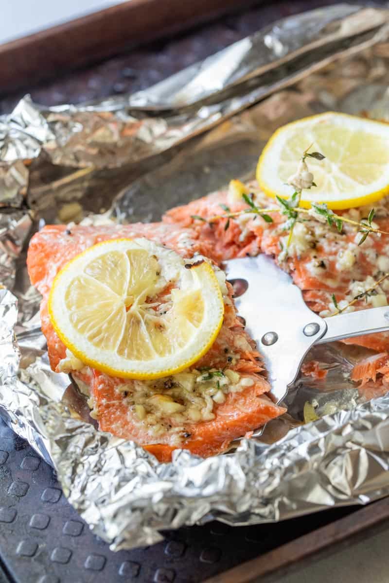 spatula picking up salmon fillet topped with lemon