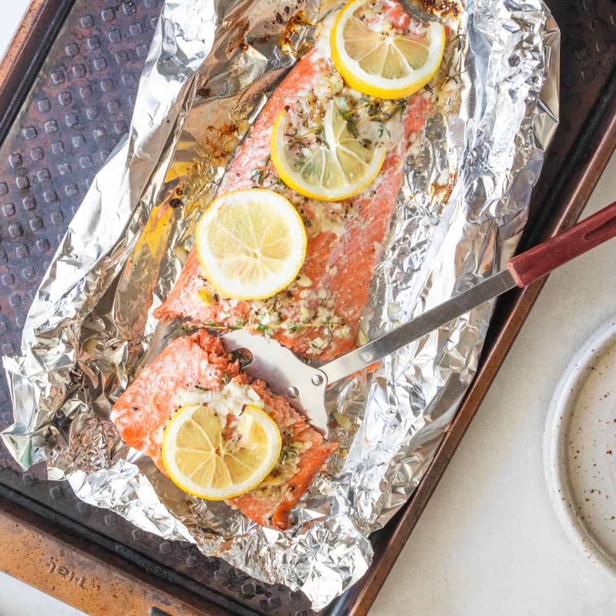 top down shot of metal spatula picking up piece of salmon