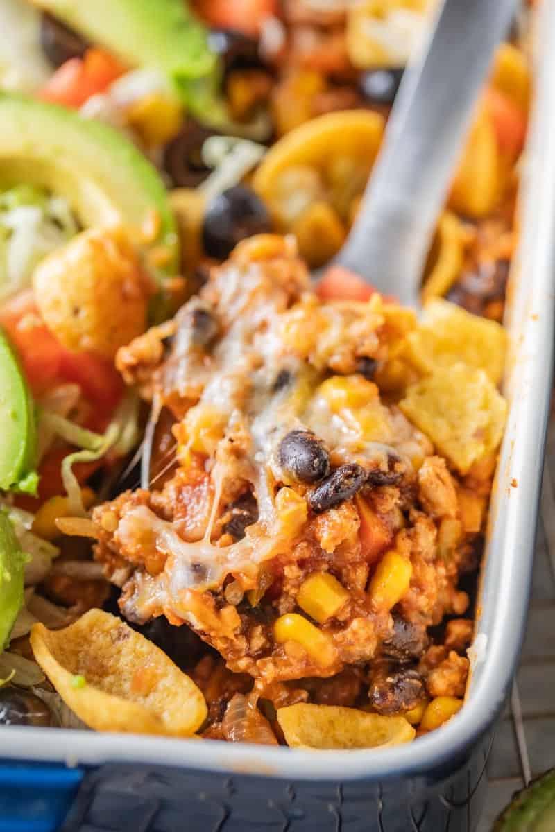 spatula scooping taco casserole from baking dish