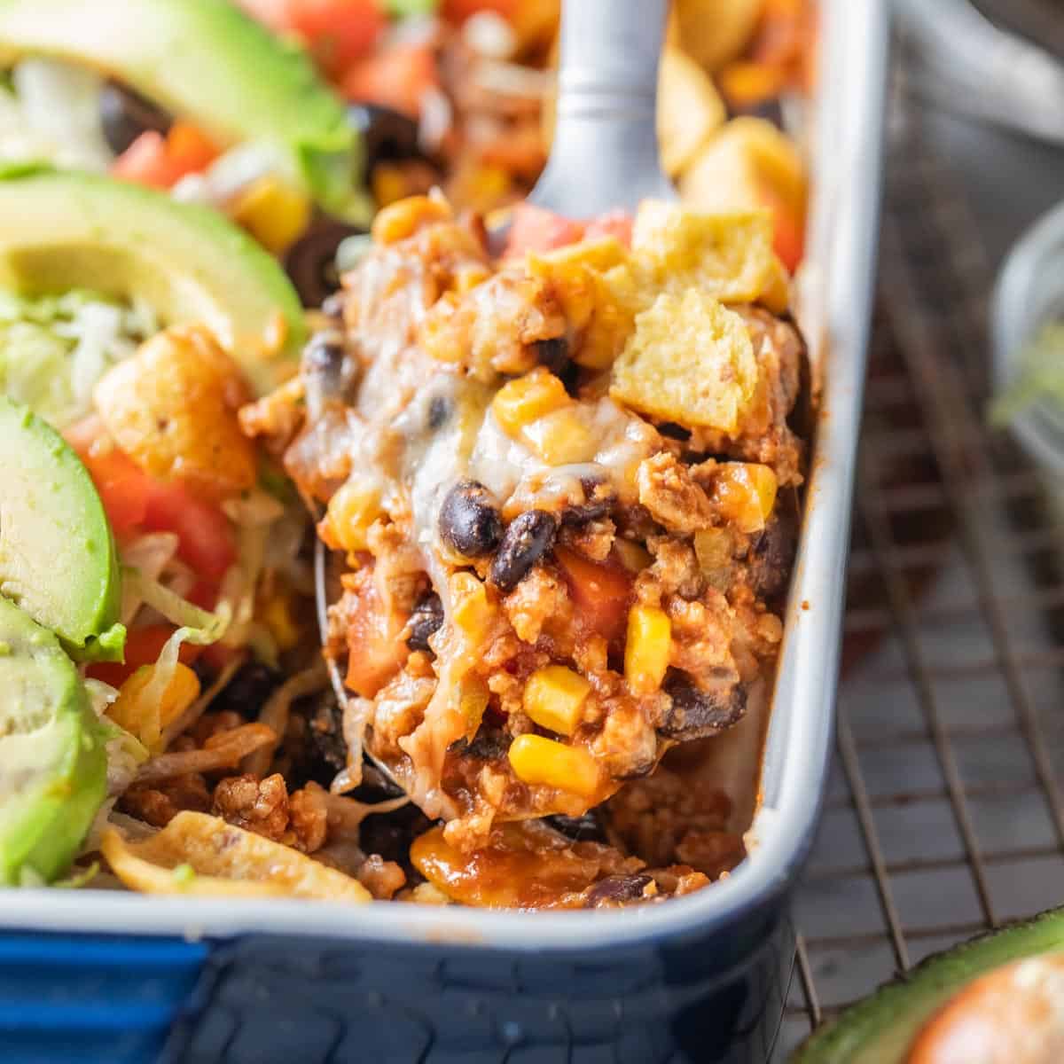 close up shot of spatula scooping taco casserole from baking dish