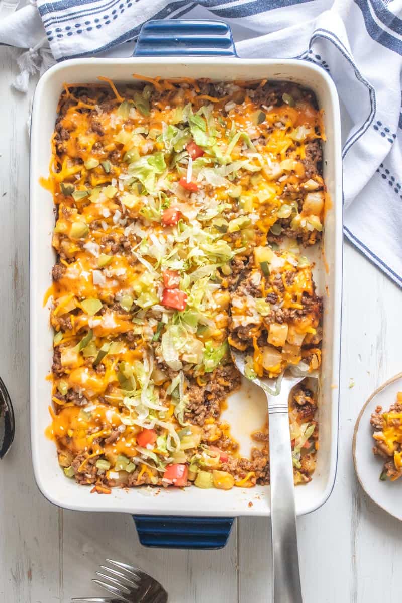 top down shot of large spoon in dish filled with cheesy hamburger casserole