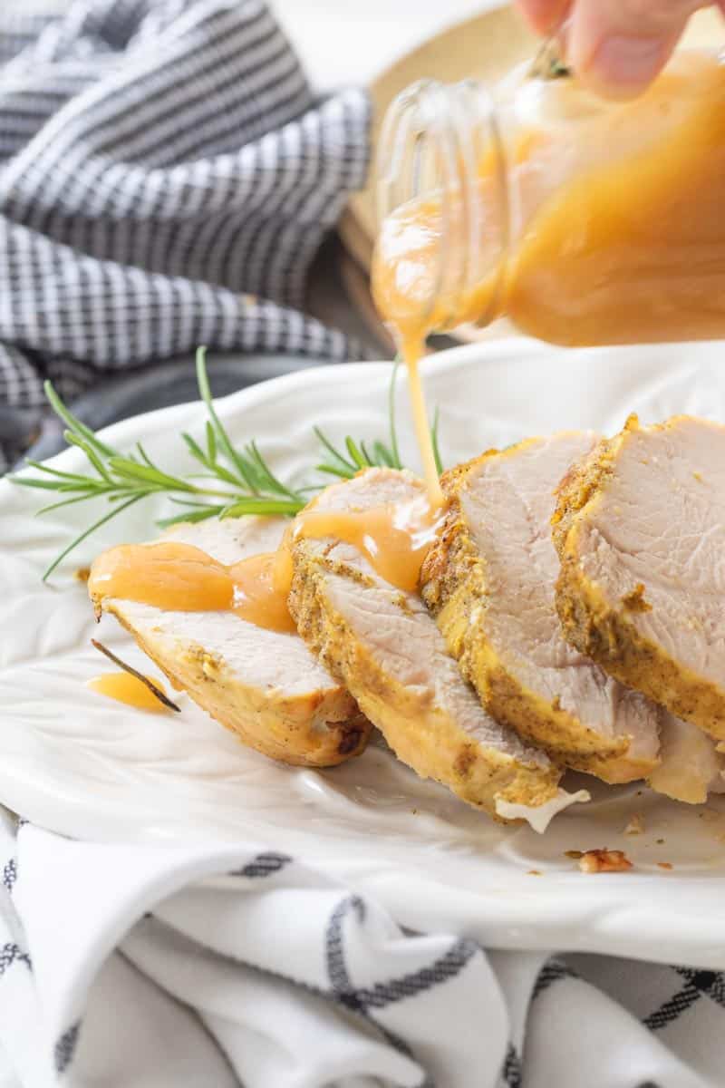 gravy drizzled on slices of turkey on a platter