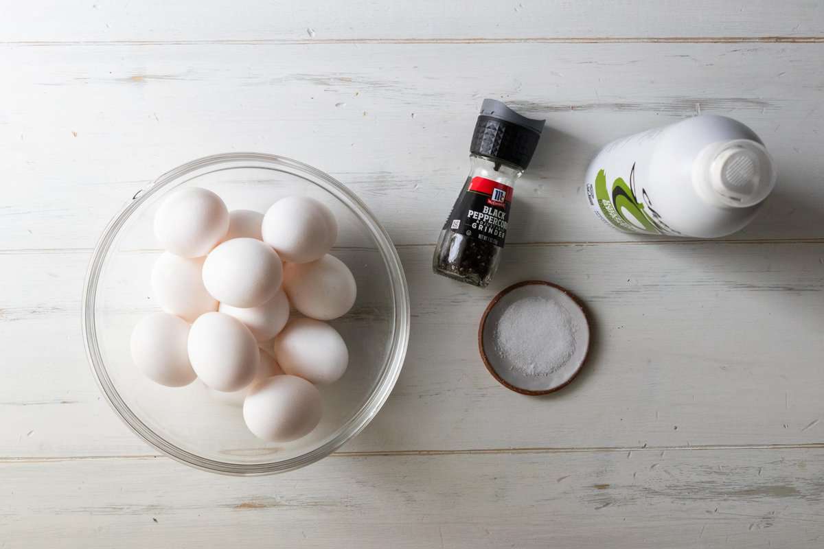 whole eggs in a bowl next to pan spray, salt and pepper all on a countertop