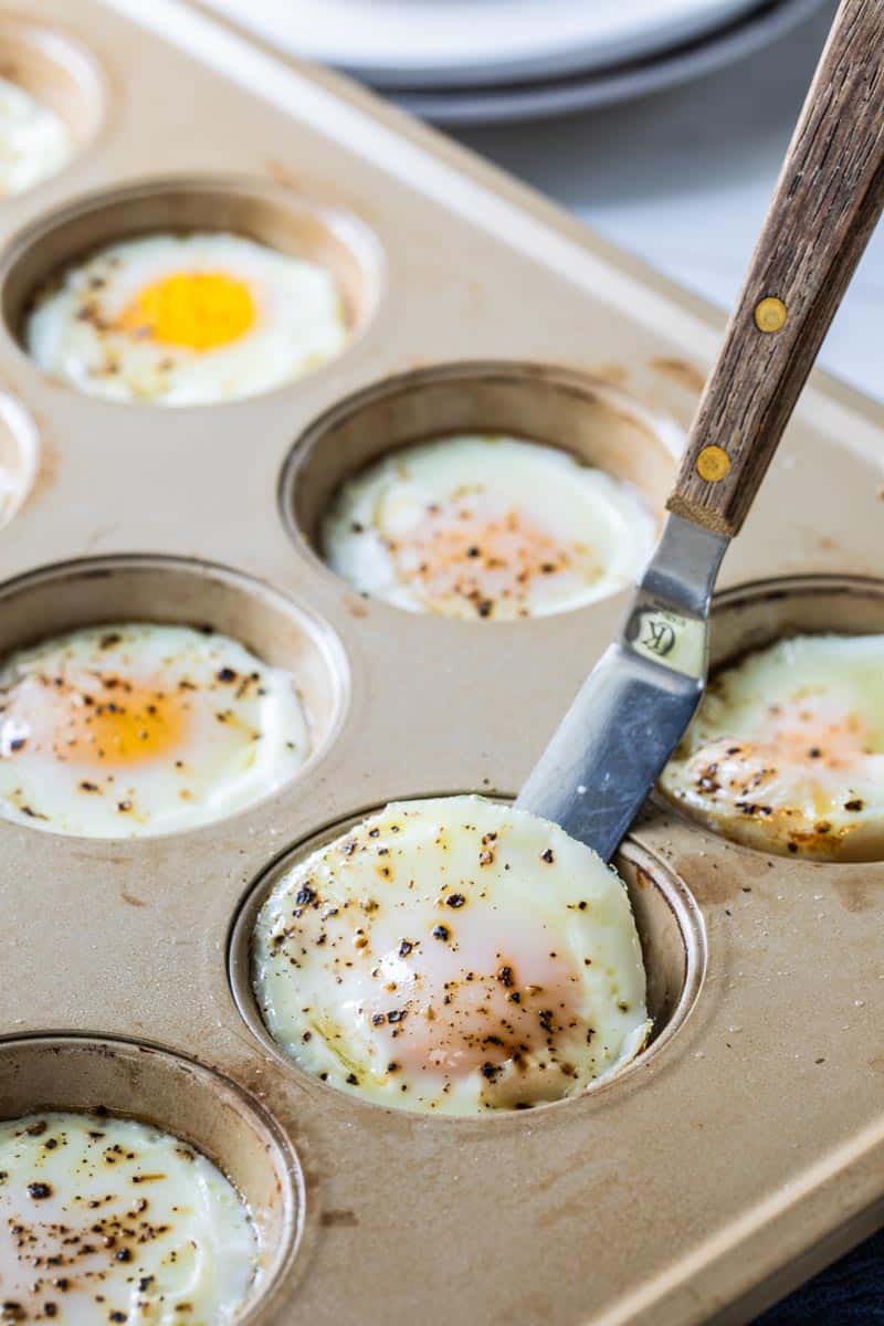 knife scooping egg bite from muffin tin