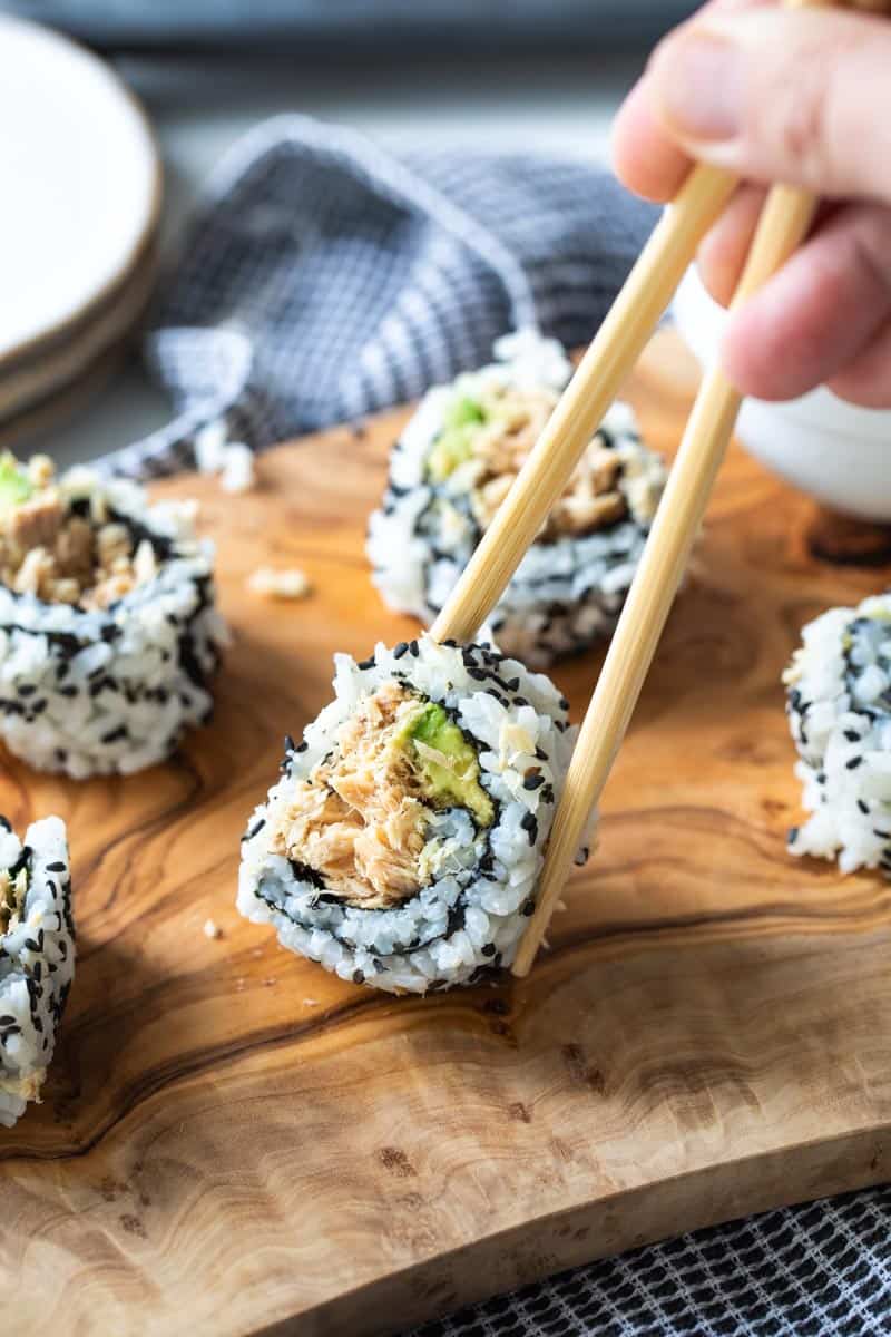 chopsticks picking up piece of sushi