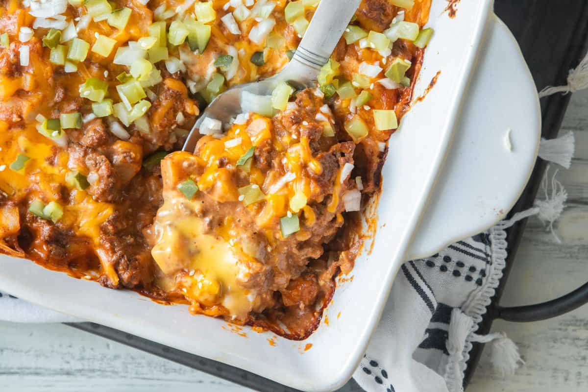 spatula scooping serving of cheeseburger casserole from baking dish