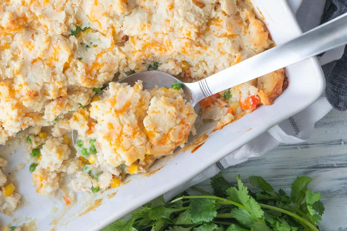 large spoon in casserole dish filled with chicken pot pie