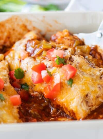 close up view of spatula scooping burrito casserole from dish