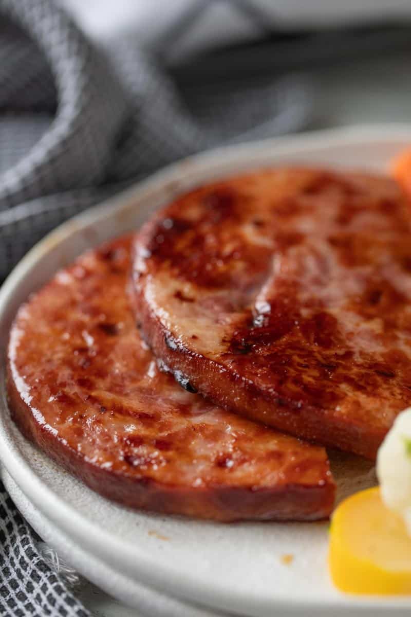 close up view of two slices of ham steak on a plate