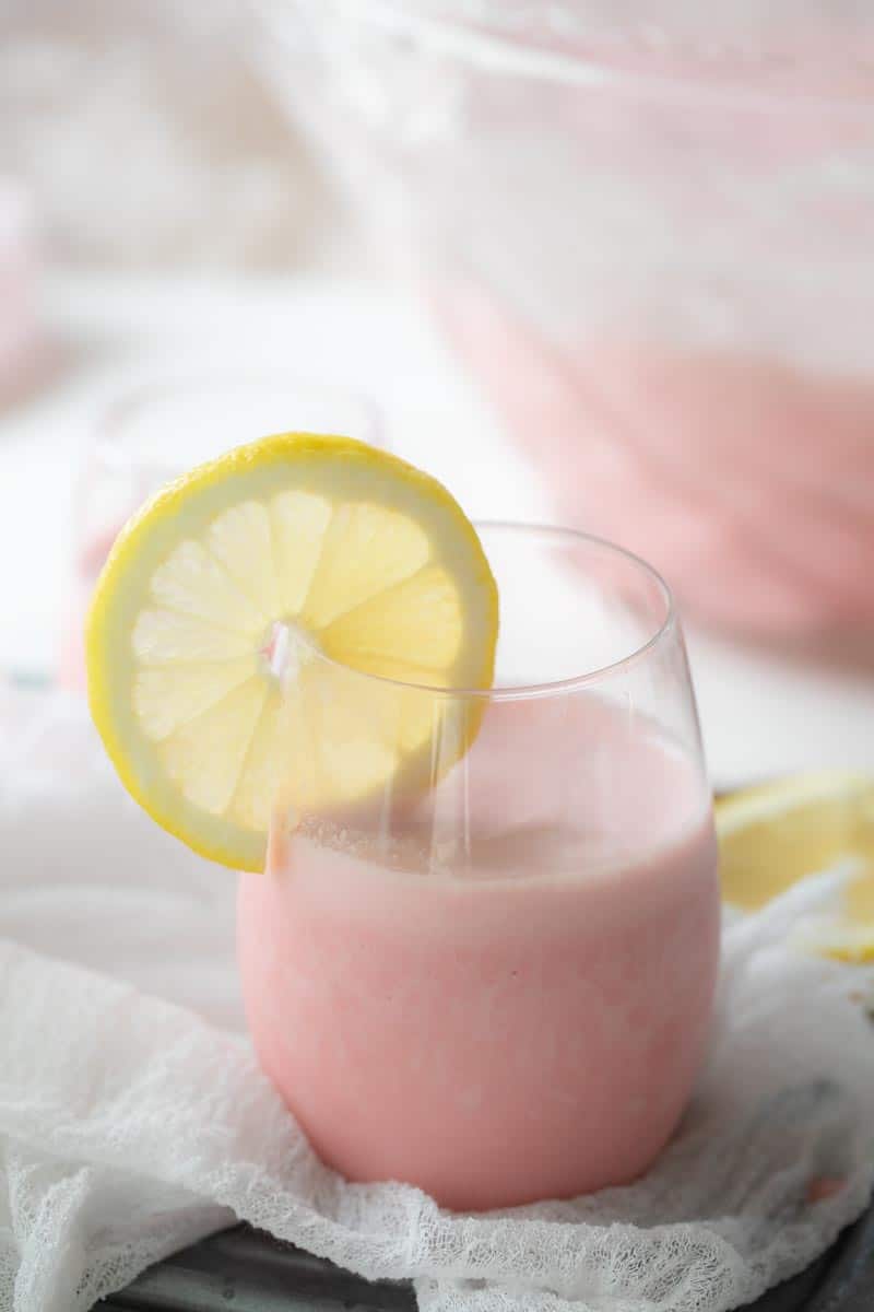 pink punch in glass with lemon slice on the side