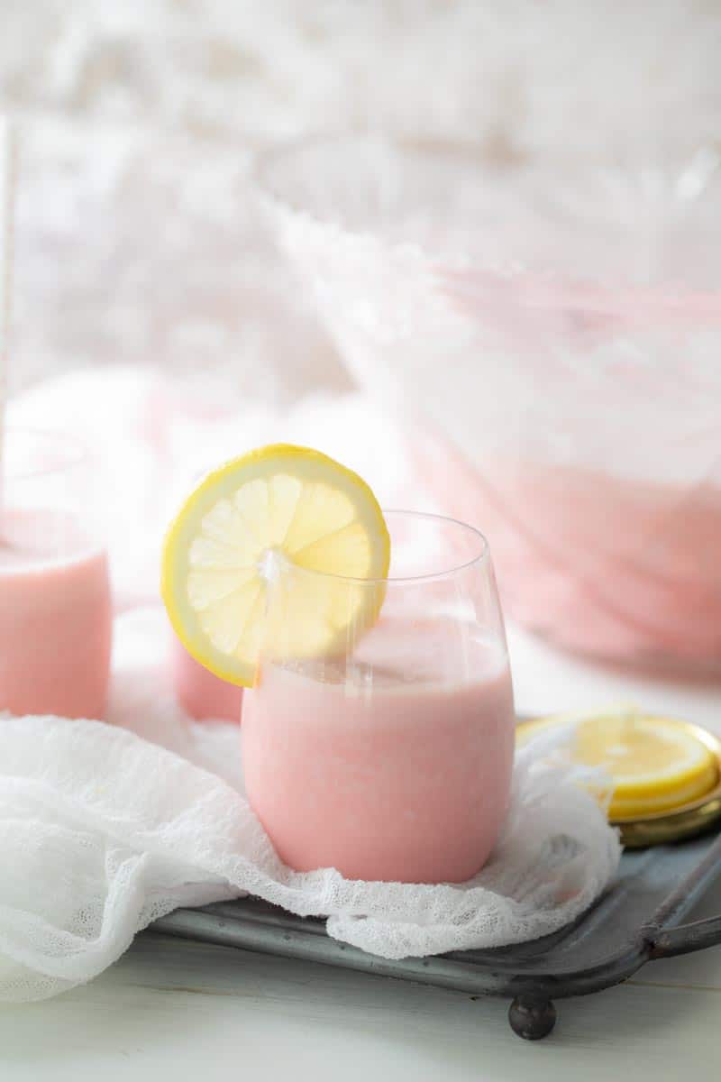 pink punch in glass with lemon slice on the side