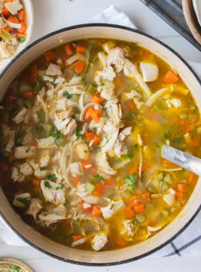 top down shot of ladle in turkey noodle soup