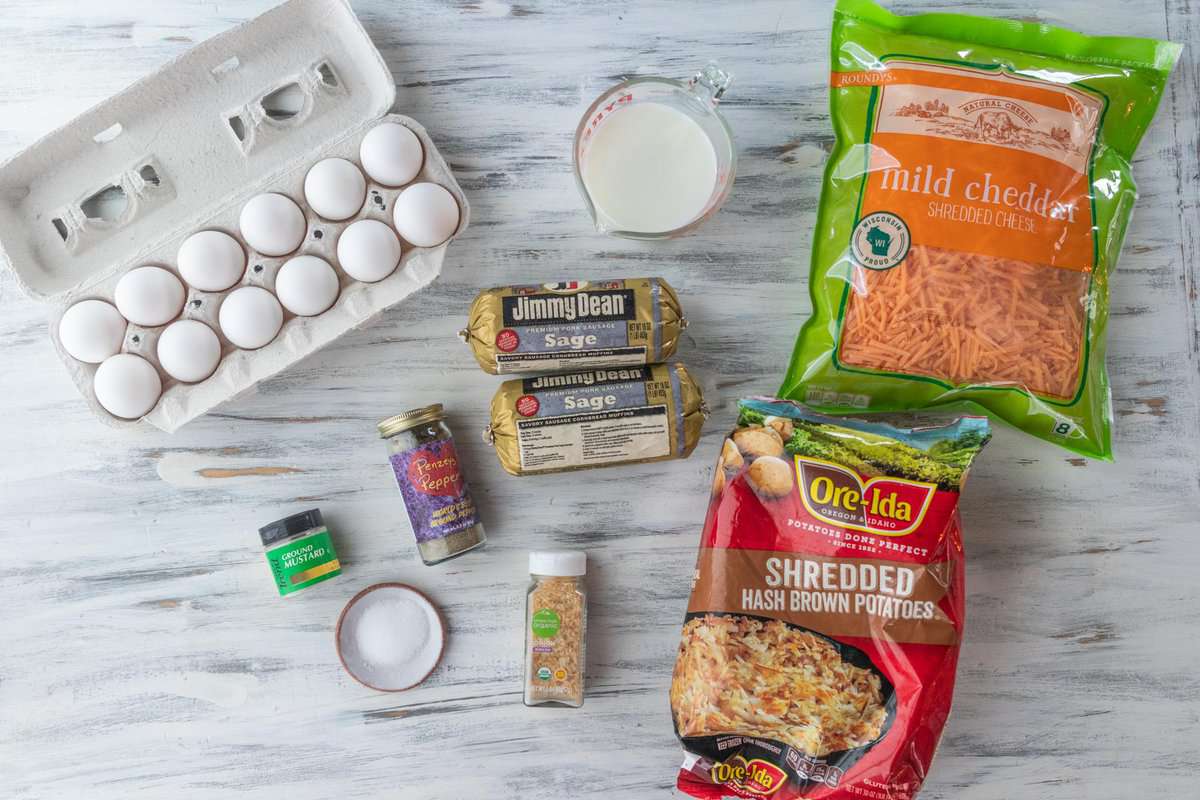 eggs, milk, cheese, hash browns, sausage and spices on a countertop