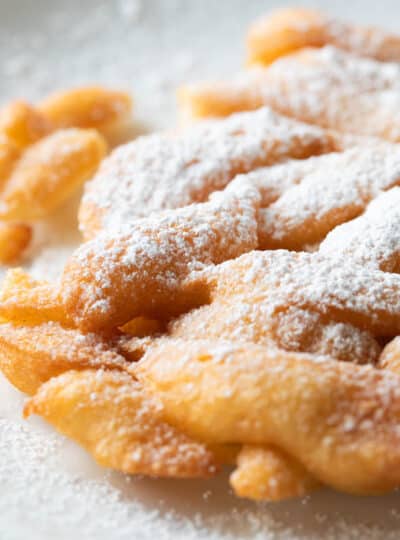 close up view of funnel cake topped with powdered sugar