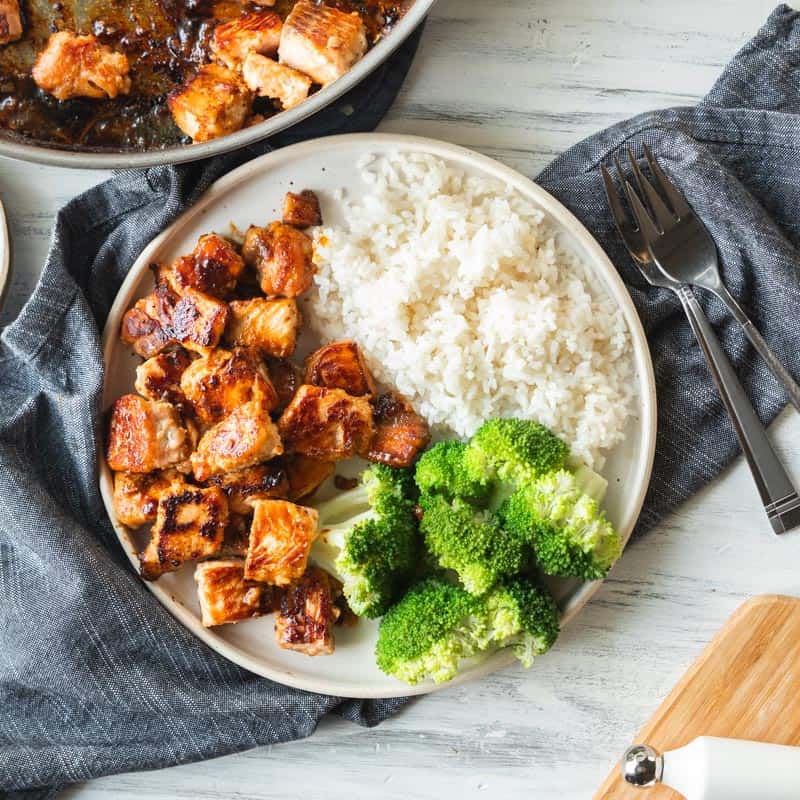 top down view of plate filled with salmon bites, broccoli and rice