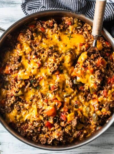 top down view of stuffed pepper casserole in a sauté pan with a serving spoon