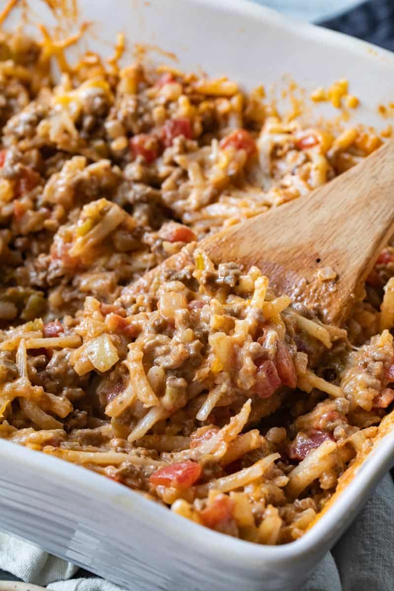 wooden spoon scooping into a dish for taco potato casserole