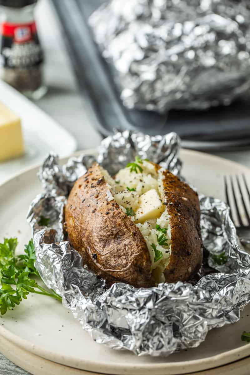 sliced open baked potato on top of foil