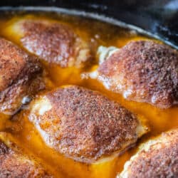 close up of cooked and seasoned chicken thighs in a slow cooker