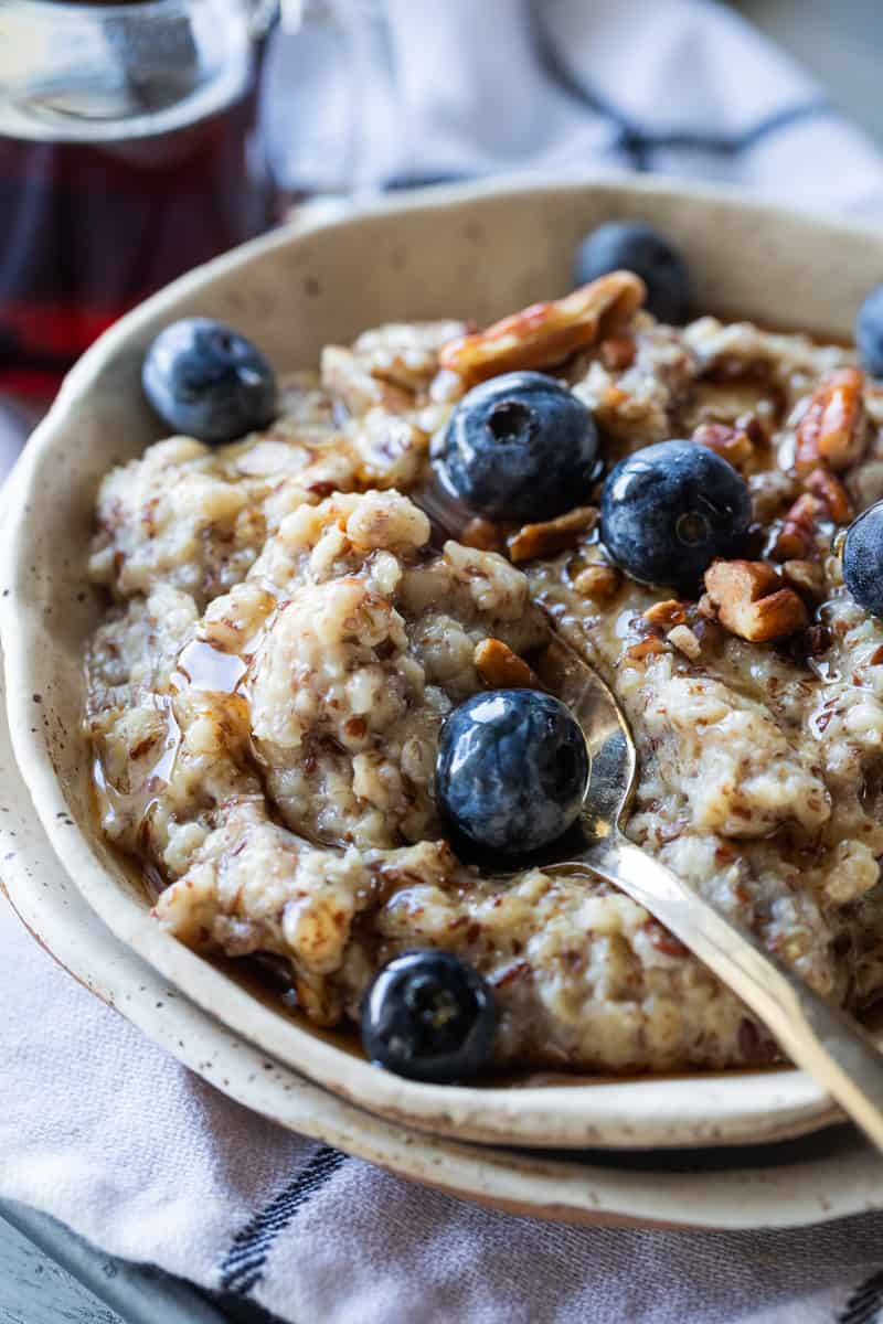 oatmeal topped with maple syrup, fresh blueberries and chopped nuts