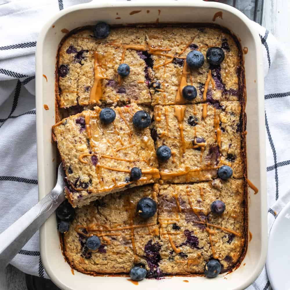 a top down view of baked oatmeal with blueberries on top in a casserole dish